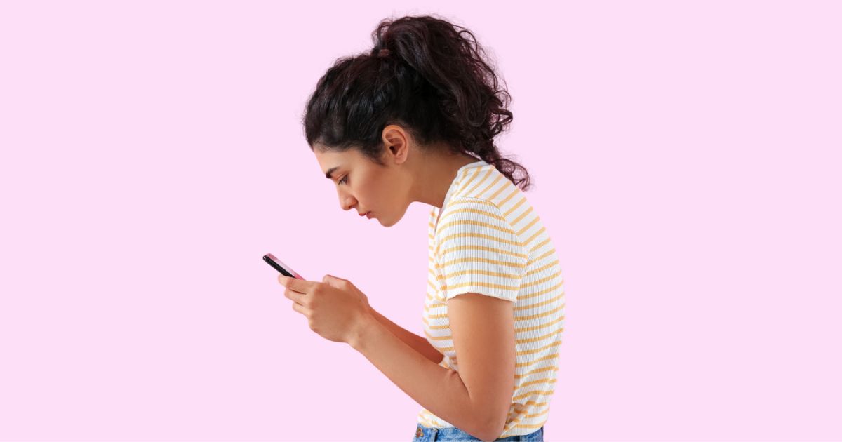 Woman slouched over looking at her phone.