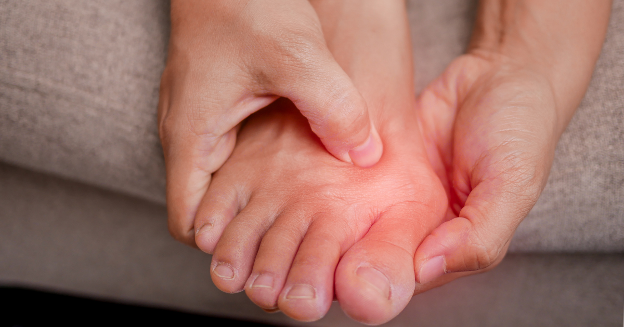 A person holding the top of their foot