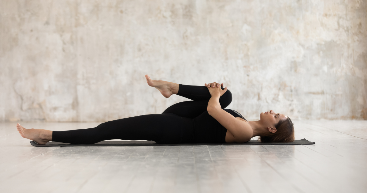 Woman performing knee-to-chest stretch