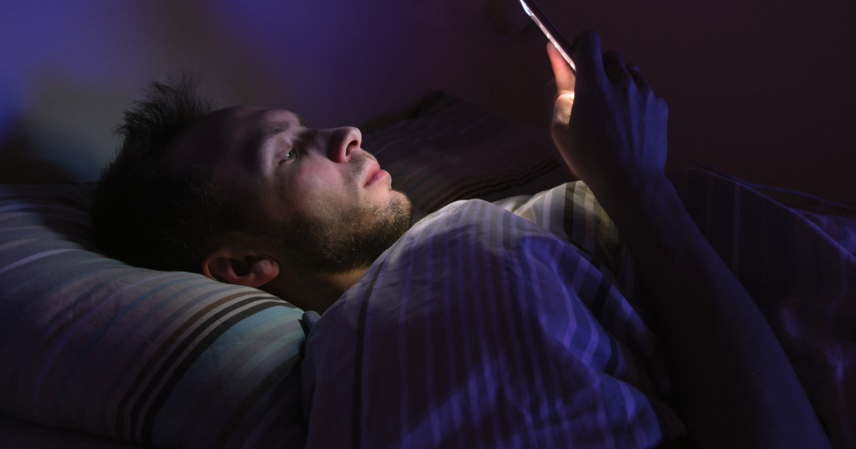 Man on his phone in bed